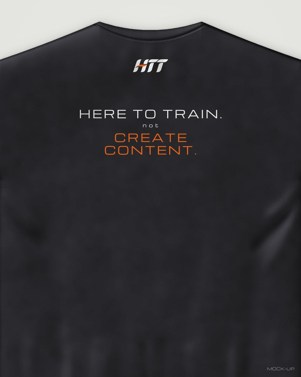 Back of a black HTT oversized tee printed HERE TO TRAIN. NOT CREATE CONTENT. (portrait crop)