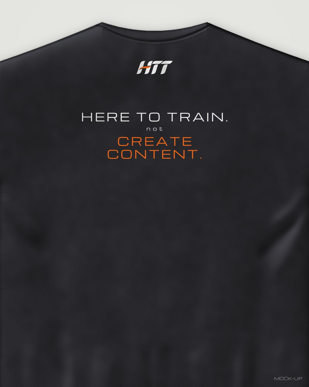 Back of a black HTT oversized tee printed HERE TO TRAIN. NOT CREATE CONTENT. (portrait crop)