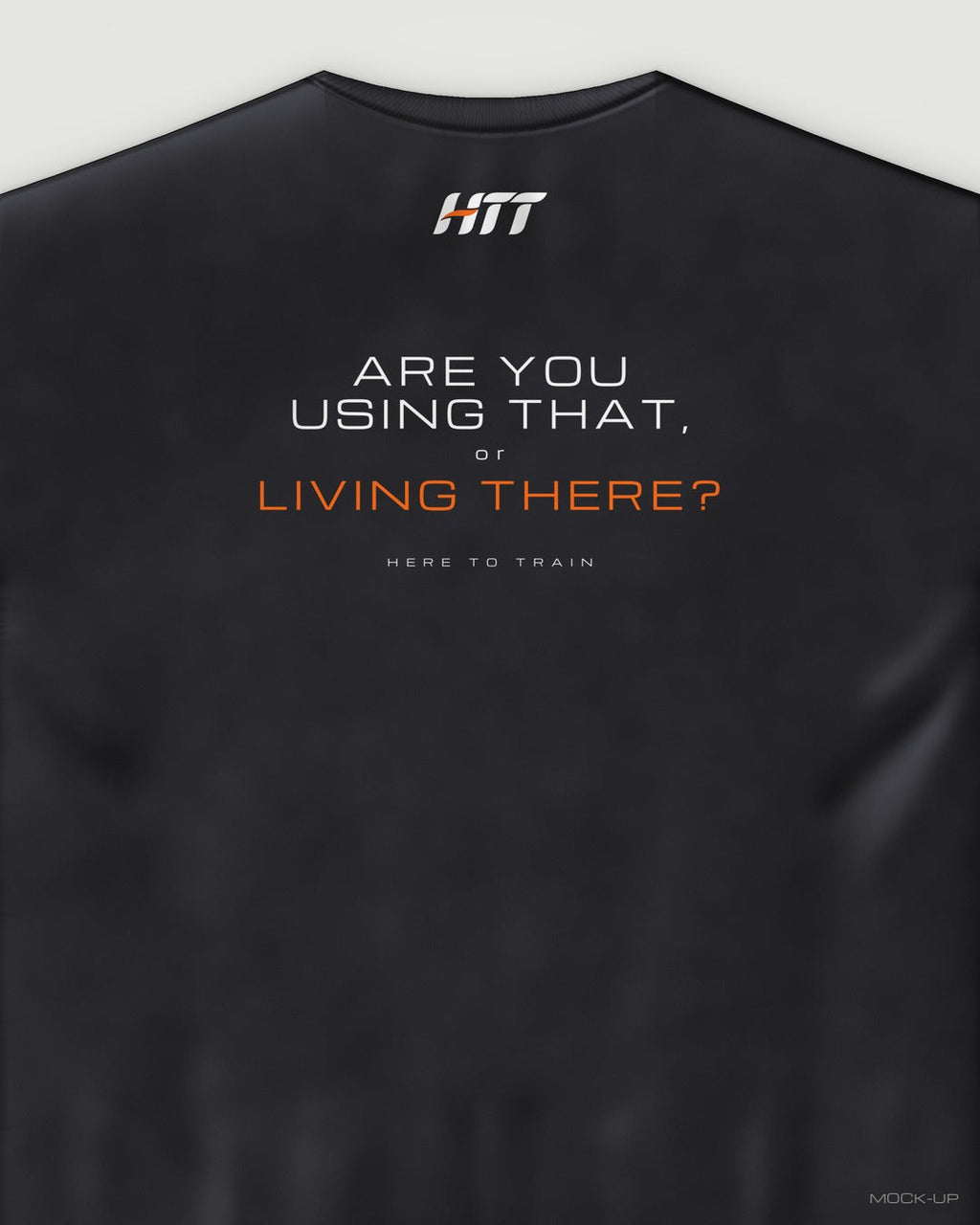 Back of a black HTT oversized tee printed ARE YOU USING THAT, OR LIVING THERE? (portrait crop)