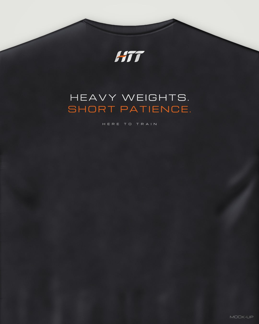 Back of a black HTT oversized tee printed HEAVY WEIGHTS. SHORT PATIENCE. (portrait crop)